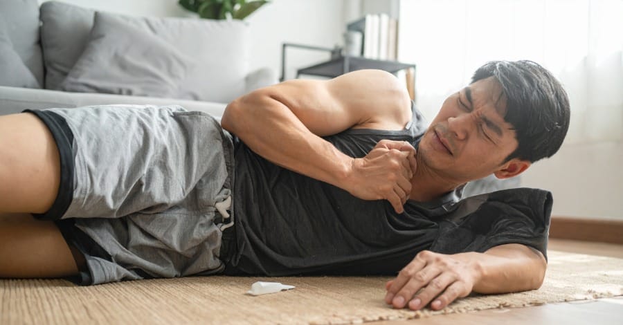 An athlete is lying on the floor with body aches after overusing Berberine